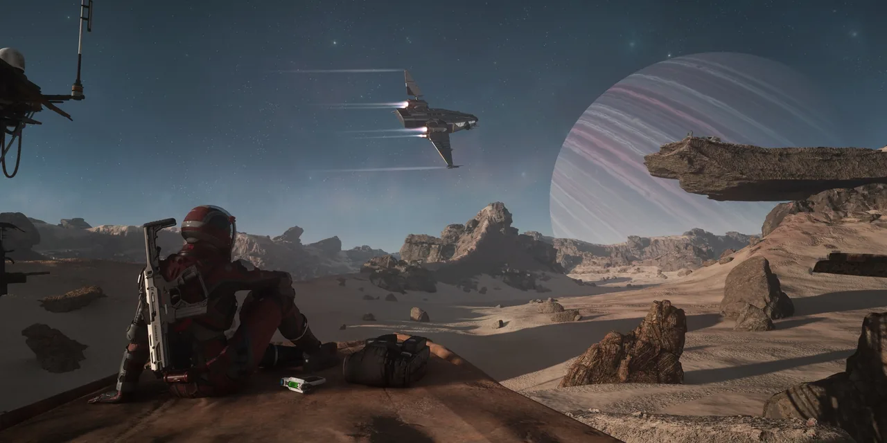 A pilot in a red flight suit sits on a rock ledge above a desert valley as a ship flies overhead, with a banded gas giant on the horizon
